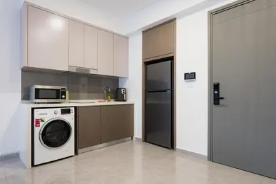 a kitchen with a washing machine and a microwave at Agile BB Residence Pavilion TRX by GB in Kuala Lumpur