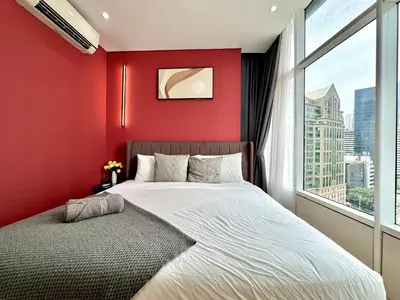 a bedroom with red walls and a bed with a window at Sky Suites Lovely 3BR Suite at KLCC in Kuala Lumpur