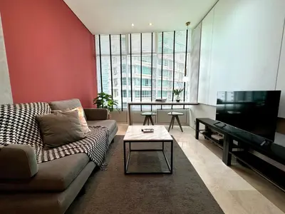 a living room with a couch and a flat screen tv at Sky Suites Lovely 3BR Suite at KLCC in Kuala Lumpur