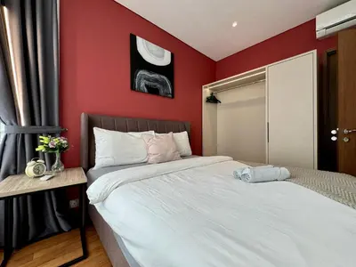 two beds in a room with red walls at Sky Suites Lovely 3BR Suite at KLCC in Kuala Lumpur