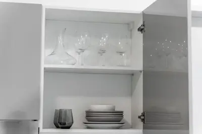 a cupboard with wine glasses and plates in it at Trion KL - 2 Bedroom, 5 pax, Netflix, Free Car Park in Kuala Lumpur