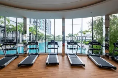 a gym with a row of treadmills next to a pool at Trion KL - 2 Bedroom, 5 pax, Netflix, Free Car Park in Kuala Lumpur