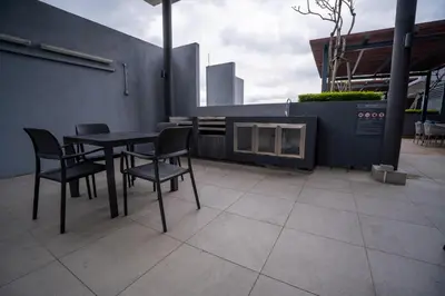 a table and chairs sitting on a patio at Neu Suites By Cozy Unit L20RA near KLCC & Jelatek LRT in Kuala Lumpur