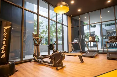a gym with exercise equipment in a room with windows at Neu Suites By Cozy Unit L20RA near KLCC & Jelatek LRT in Kuala Lumpur