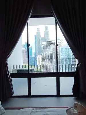 a bedroom with a view of a city from a window at COL18B Modern Infinity Pool KLCC Balcony View in Kuala Lumpur