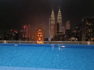 a swimming pool with a view of the city at night at COL 14A Modern Infinity Pool KLCC View with Balcony in Kuala Lumpur