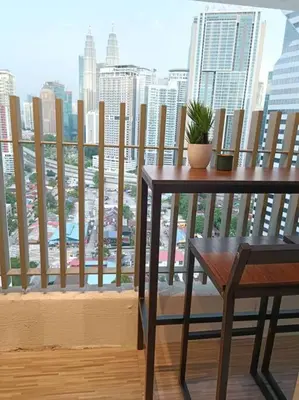 a table and chair on a balcony with a view of a city at COL 14B Modern Infinity Pool KLCC Balcony View in Kuala Lumpur
