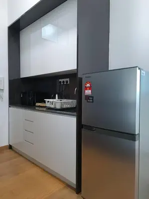 a kitchen with a stainless steel refrigerator and a counter at LUX 39B KLCC view Studio in Kuala Lumpur
