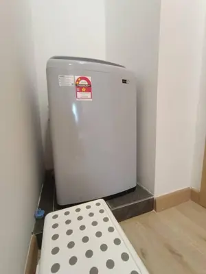 a small white refrigerator in a room with a stool at COL 27A KLCC View Infinity Pool View in Kuala Lumpur