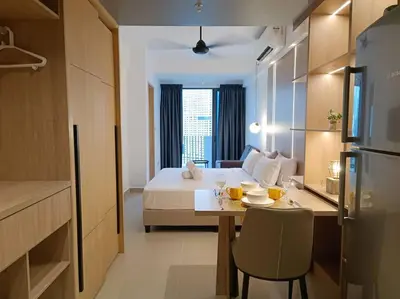 a room with a bed and a table and a kitchen at COL137A Modern Balcony KLCC View & Infinity Pool in Kuala Lumpur