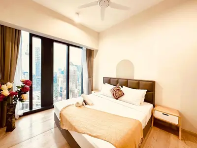 a bedroom with a bed and a large window at Star Serviced Suite KLCC in Kuala Lumpur