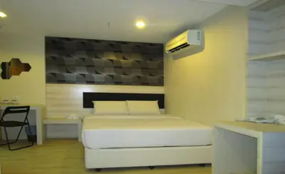 a bedroom with a white bed and a desk at T-Hotel Bukit Bintang in Kuala Lumpur