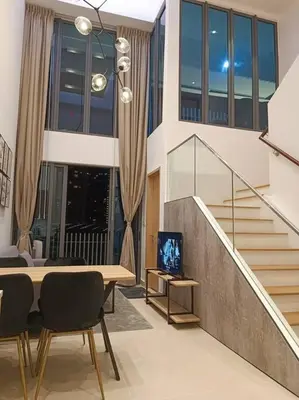 a living room with a table and chairs and stairs at COL 915A Modern Duplex Studio KLCC in Kuala Lumpur