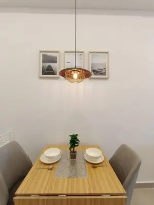 a dining room table with a potted plant and a chandelier at COL 29A Cozy KLCC View & Infinity Pool in Kuala Lumpur