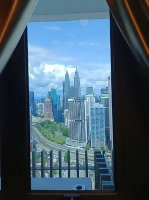a view of a city skyline from a window at COL 29A Cozy KLCC View & Infinity Pool in Kuala Lumpur
