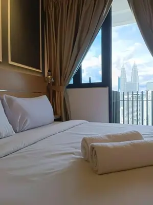a bedroom with a bed with white sheets and a window at COL 29B Cozy Studio with KLCC Balcony View in Kuala Lumpur