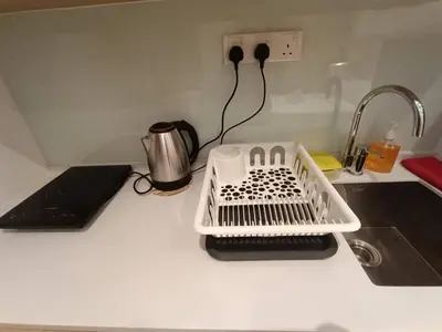 a kitchen counter with a dish drying rack next to a sink at COL 30B KL Tower View Cozy Studio in Kuala Lumpur