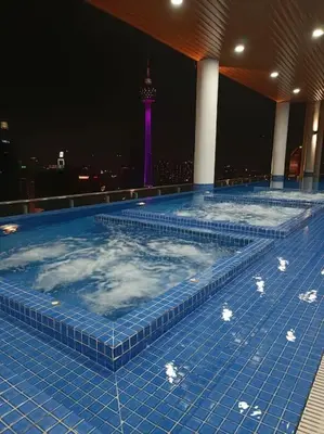 a large swimming pool with a tower in the background at COL 23aB Cozy KLCC View & Infinity Pool Studio in Kuala Lumpur