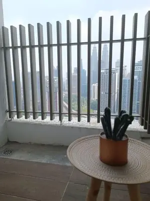 a potted plant sitting on a table in front of a window at COL 23aB Cozy KLCC View & Infinity Pool Studio in Kuala Lumpur
