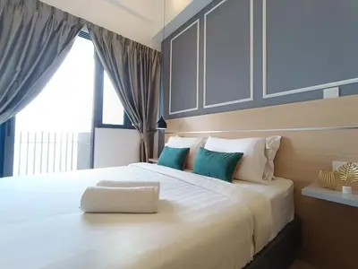 a bedroom with a large white bed with blue pillows at COL 23aB Cozy KLCC View & Infinity Pool Studio in Kuala Lumpur