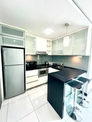a kitchen with white cabinets and a black counter top at KL Homestay at Casa Residency- Walk to Lalaport & LRT in Kuala Lumpur