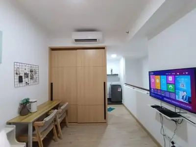 a room with a desk and a large monitor on the wall at COL 93B Balcony KLCC View & Infinity Pool Studio in Kuala Lumpur