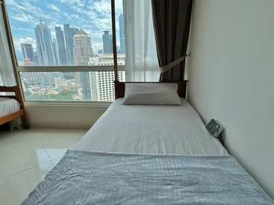 a bed in a room with a large window at Hushed Dorm KL in Kuala Lumpur
