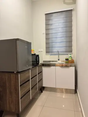 a kitchen with a sink and a large television at Studio Stay in Kuala Lumpur