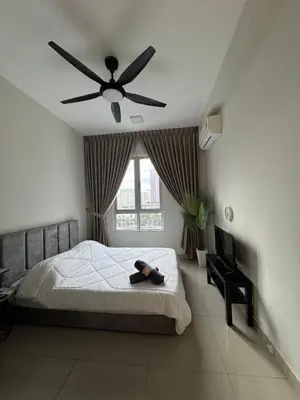 a bedroom with a bed with a ceiling fan at Studio Stay in Kuala Lumpur