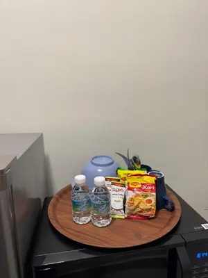 a tray of food and drinks on top of a microwave at Studio Stay in Kuala Lumpur