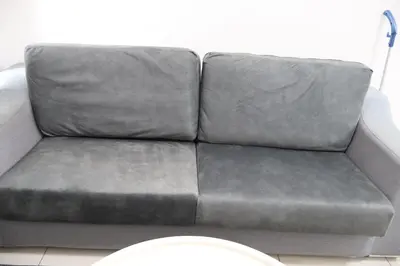 a grey couch sitting in a room with a white wall at Cozy kenwingston Platz KL 2-5 pax 2BR&2BR genting view parkin netflix 3802 in Kuala Lumpur