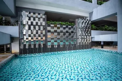 a swimming pool in a building with blue water at Neu Suites By Cozy Unit L20RB near KLCC & Jelatek LRT in Kuala Lumpur