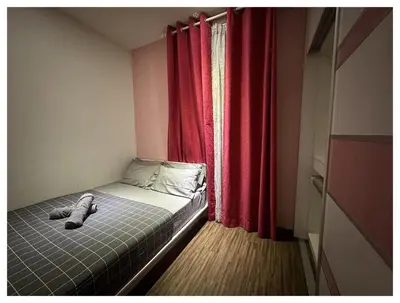 a small bedroom with a bed with red curtains at Setapak Central Premium Suites in Kuala Lumpur