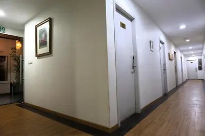 a hallway with white doors and a wooden floor at ECO Hotel at BBCC in Kuala Lumpur