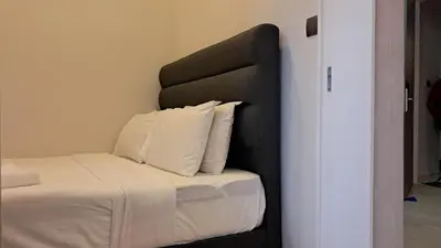 a bed with a black headboard and white pillows at STAR Residence KLCC City Centre in Kuala Lumpur