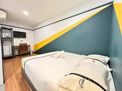 a bedroom with a bed with a blue and yellow wall at Sky Hotel Cheras Maluri in Kuala Lumpur
