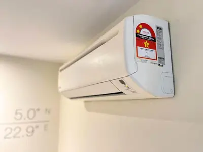 a white microwave hanging on a wall at Sky Hotel Cheras Maluri in Kuala Lumpur