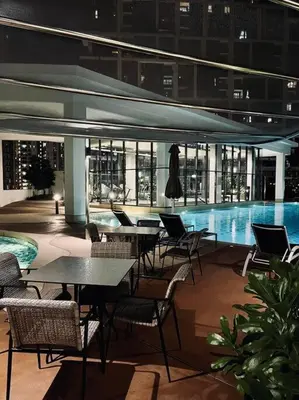 a patio with tables and chairs next to a swimming pool at Ooak suites Mont Kiara 163 \uc624\ud06c\uc2a4\ud14c\uc774 in Kuala Lumpur