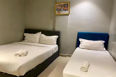 two beds in a room with towels on them at Hotel Dlima House Bukit Bintang in Kuala Lumpur