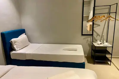 a room with two beds and a shelf with a mirror at Hotel Dlima House Bukit Bintang in Kuala Lumpur