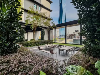 a courtyard with tables and chairs in a building at Opus Residences by Wakely Kuala Lumpur in Kuala Lumpur
