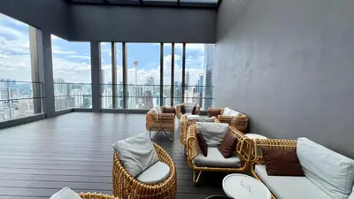 a balcony with wicker chairs and tables on a building at Cozy Axon Residence Bukit Bintang by Konoha Suites 1-3pax in Kuala Lumpur