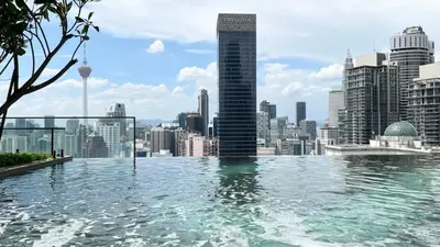 a infinity pool with a view of a city at Cozy Axon Residence Bukit Bintang by Konoha Suites 1-3pax in Kuala Lumpur