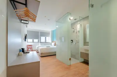 a room with a bed and a bathroom with a shower at Upper Hotel Suites KL Sentral in Kuala Lumpur