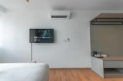 a bedroom with a bed and a tv on the wall at Upper Hotel Suites KL Sentral in Kuala Lumpur