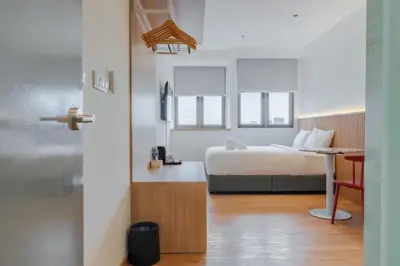 a bedroom with a bed and a desk with a chair at Upper Hotel Suites KL Sentral in Kuala Lumpur