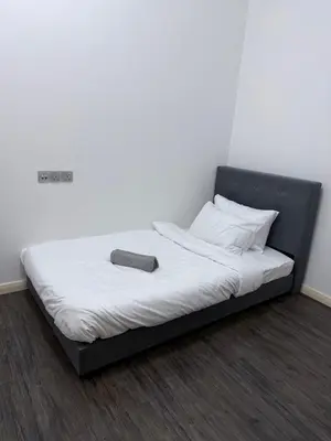 a bed with a black frame and a book on it at Cozy Downtown 2BR at M Suites, Embassy Row in Kuala Lumpur