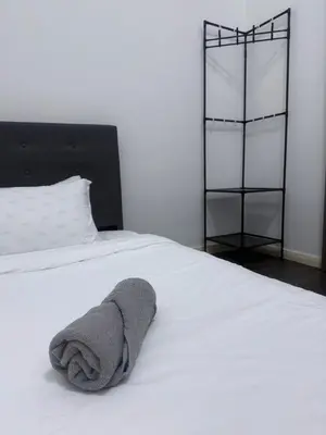 a towel laying on top of a white bed at Cozy Downtown 2BR at M Suites, Embassy Row in Kuala Lumpur