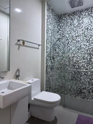a bathroom with a toilet and a sink and a shower at Cozy Downtown 2BR at M Suites, Embassy Row in Kuala Lumpur