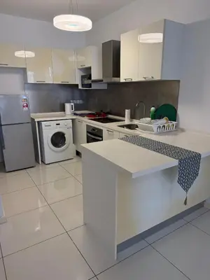 a kitchen with a stove and a washer and dryer at Cozy Downtown 2BR at M Suites, Embassy Row in Kuala Lumpur